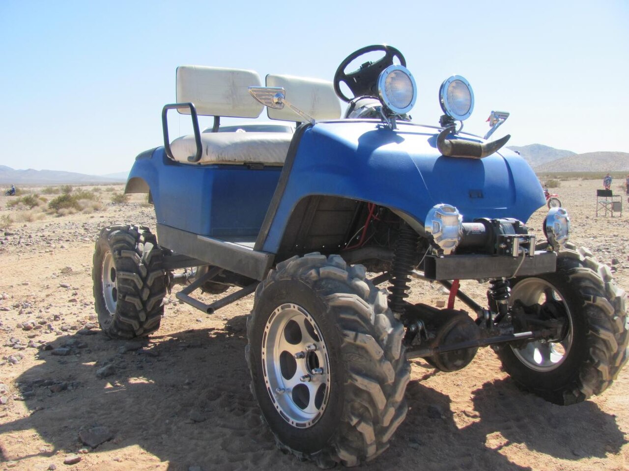 Lifted golf cart fitted with large off-road tires