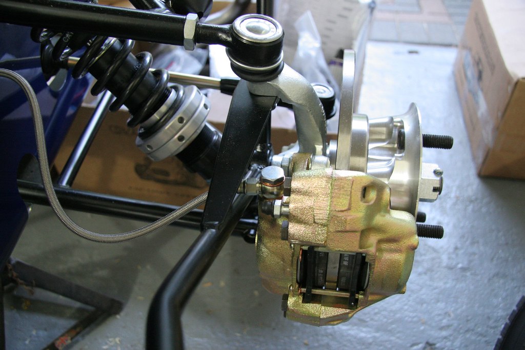 Close-up of golf cart suspension, shock and brake assembly during a lift kit install